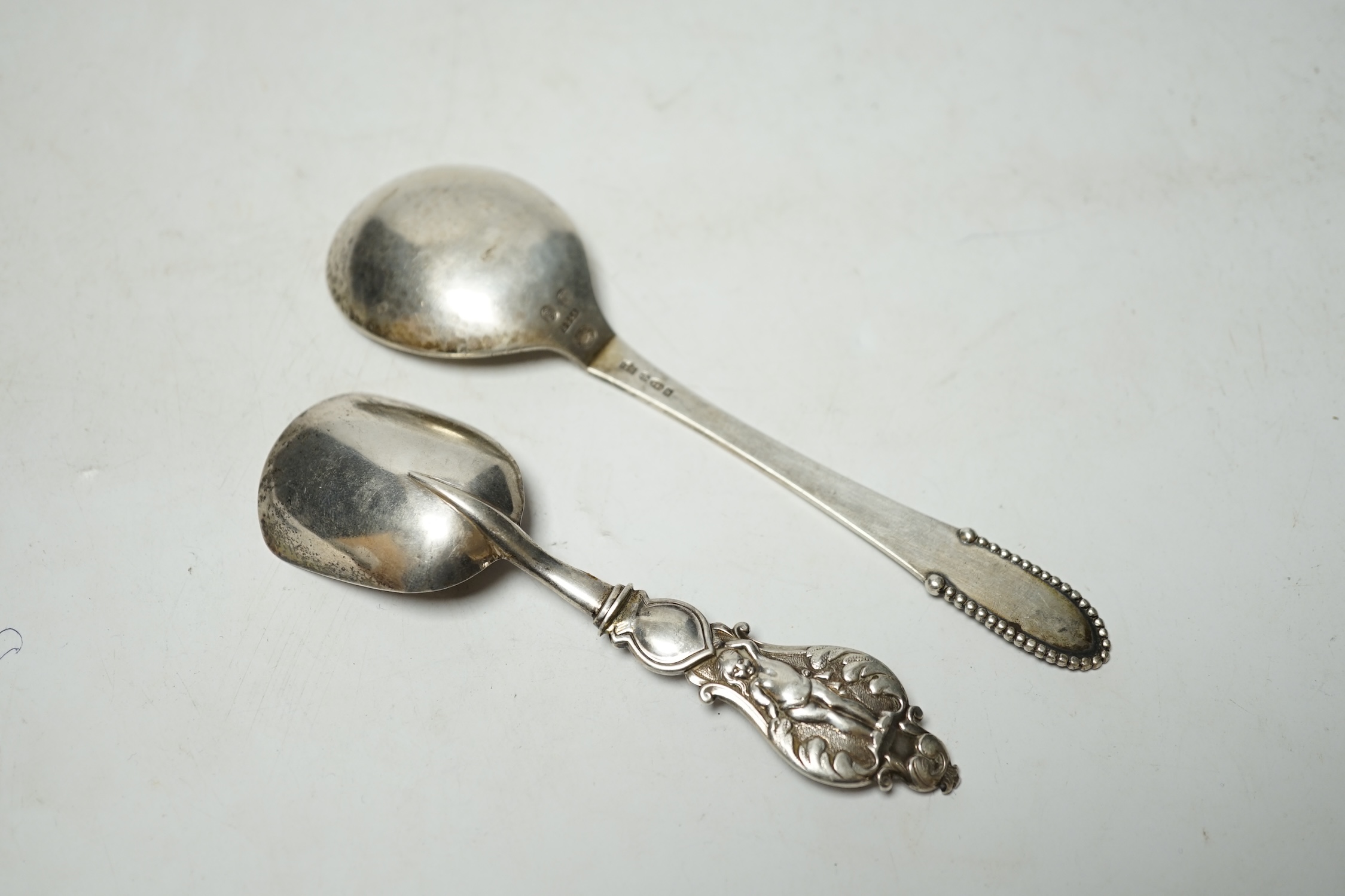 A George IV silver caddy spoon, Taylor & Perry, Birmingham, 1829, 11.4cm, together with a George V silver Georg Jensen spoon, import marks for London, 1923. Condition - fair